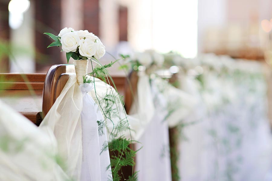 Kirchenbank Deko zur Hochzeit mit weißen Rosen