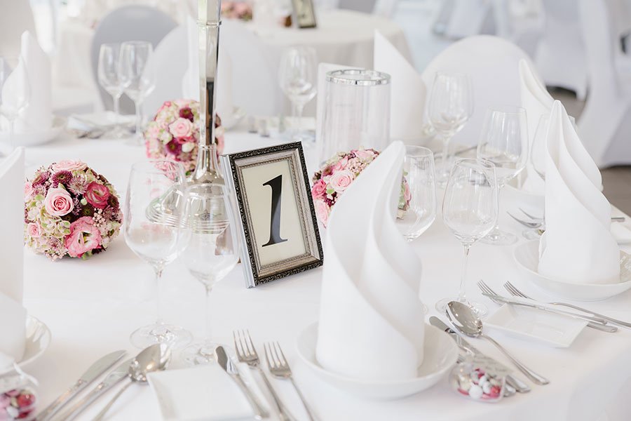 Nahaufnahme der Tischdeko bei der Hochzeit in Altrosa mit Tischnummer im Bilderrahmen