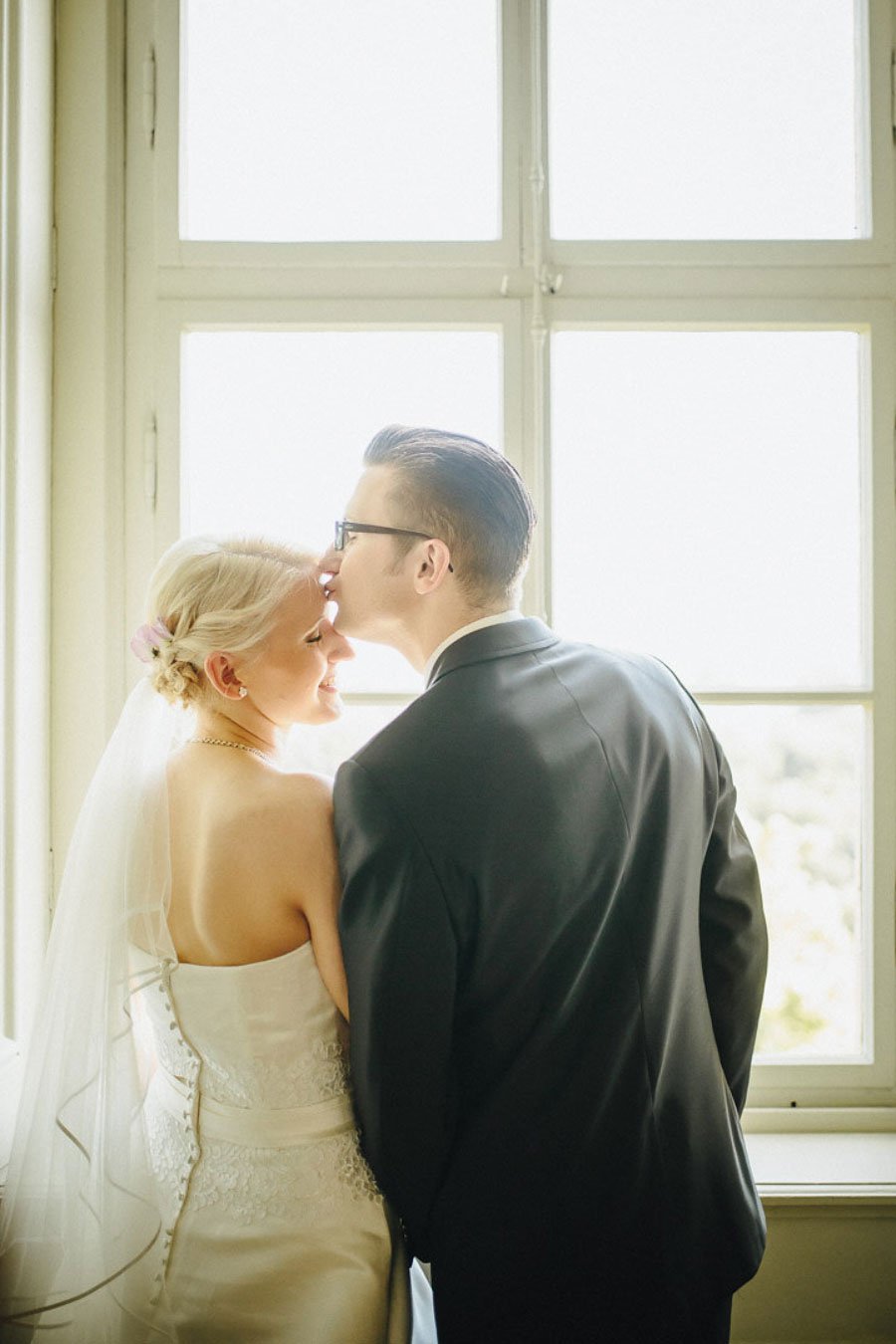 Braut und Bräutigam stehen am Fenster