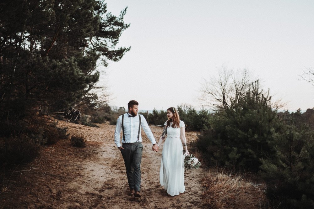 Braut und Bräutigam laufen Weg entlang