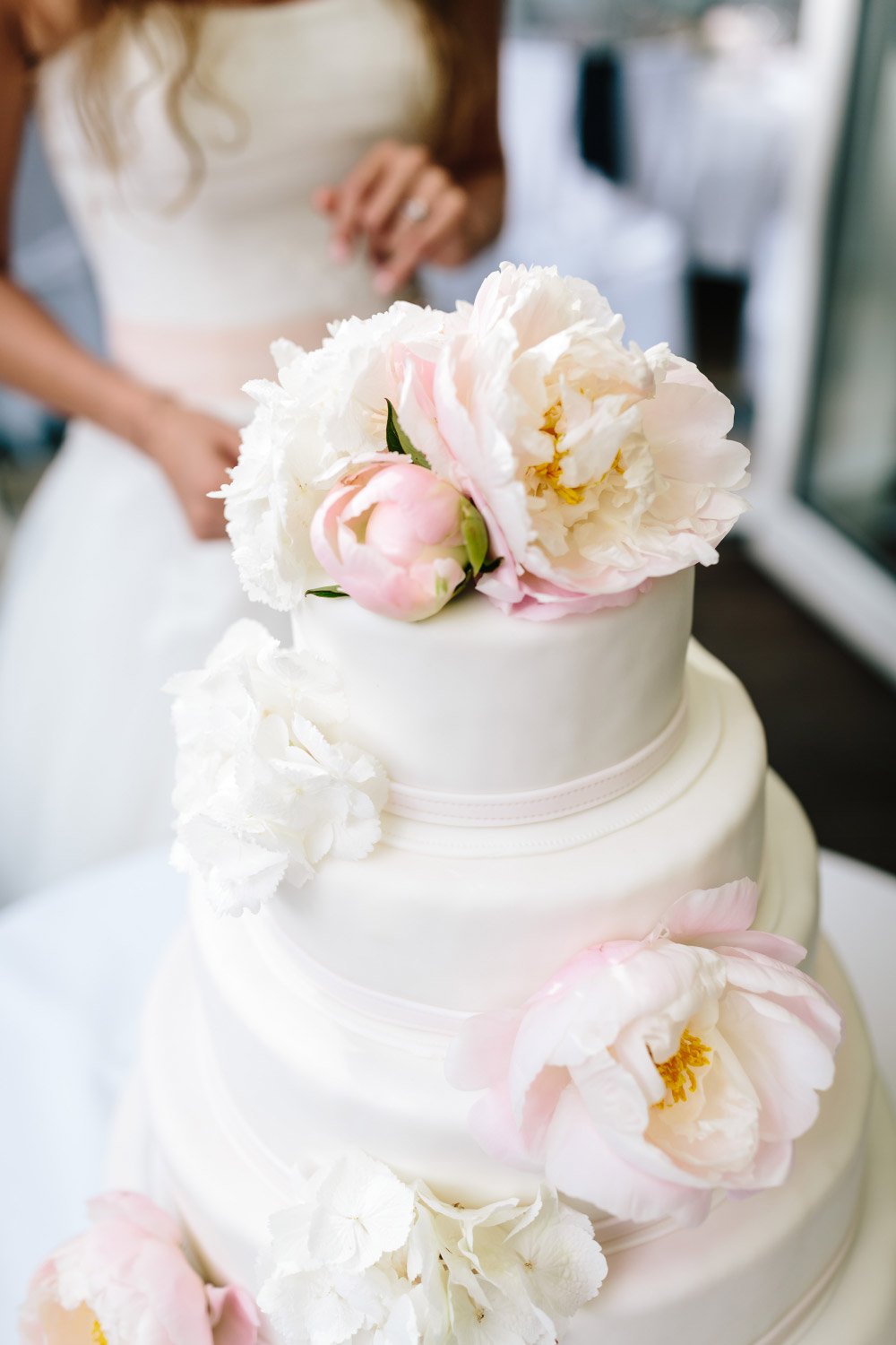 Hochzeitstorte in Weiß mit Blüten dekoriert