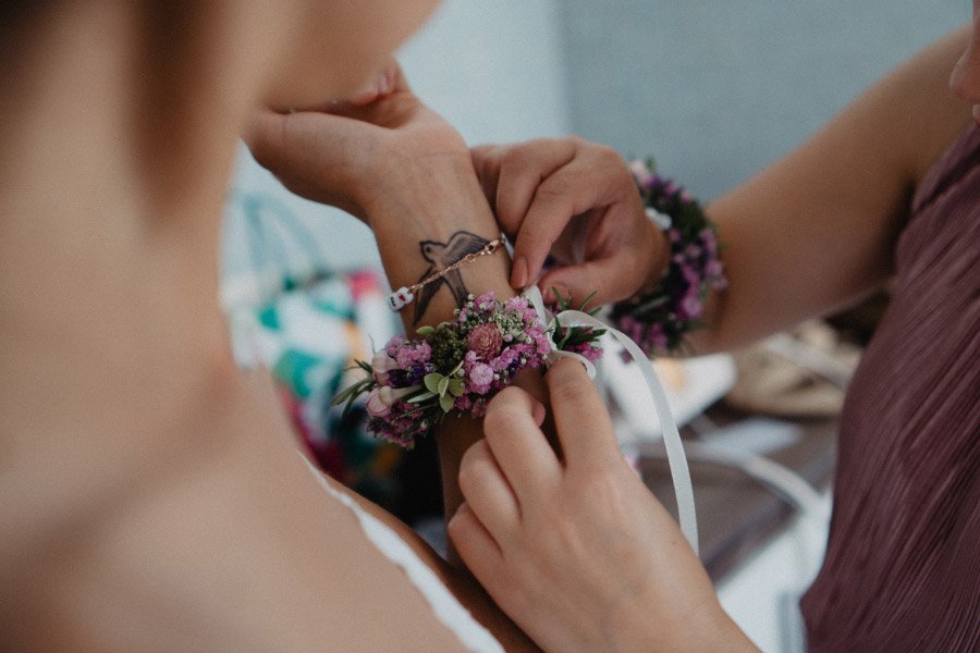 Brautjungfer bekommt Blumenarmband angesteckt