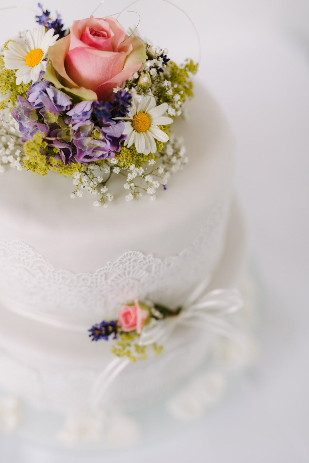 Weiß eingedeckte Hochzeitstorten mit echten Wiesenblumen