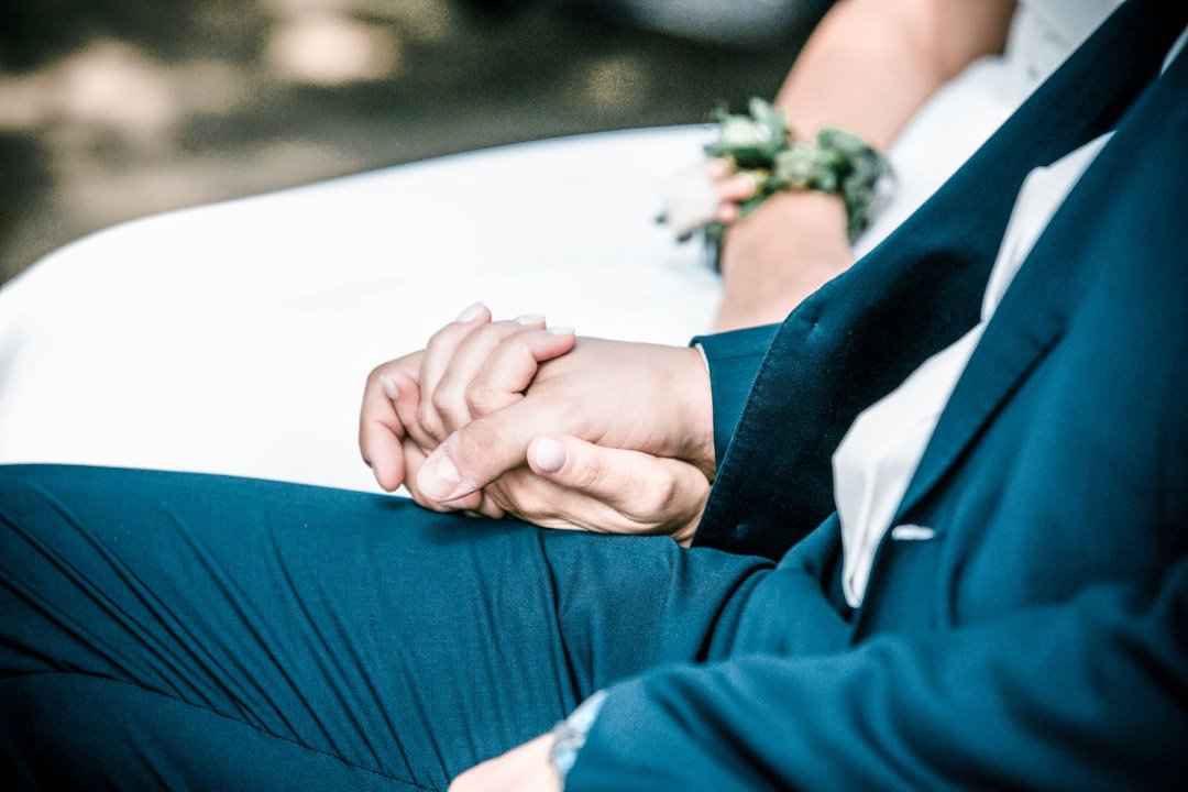 Braut und Bräutigam halten Händchen bei der Trauung