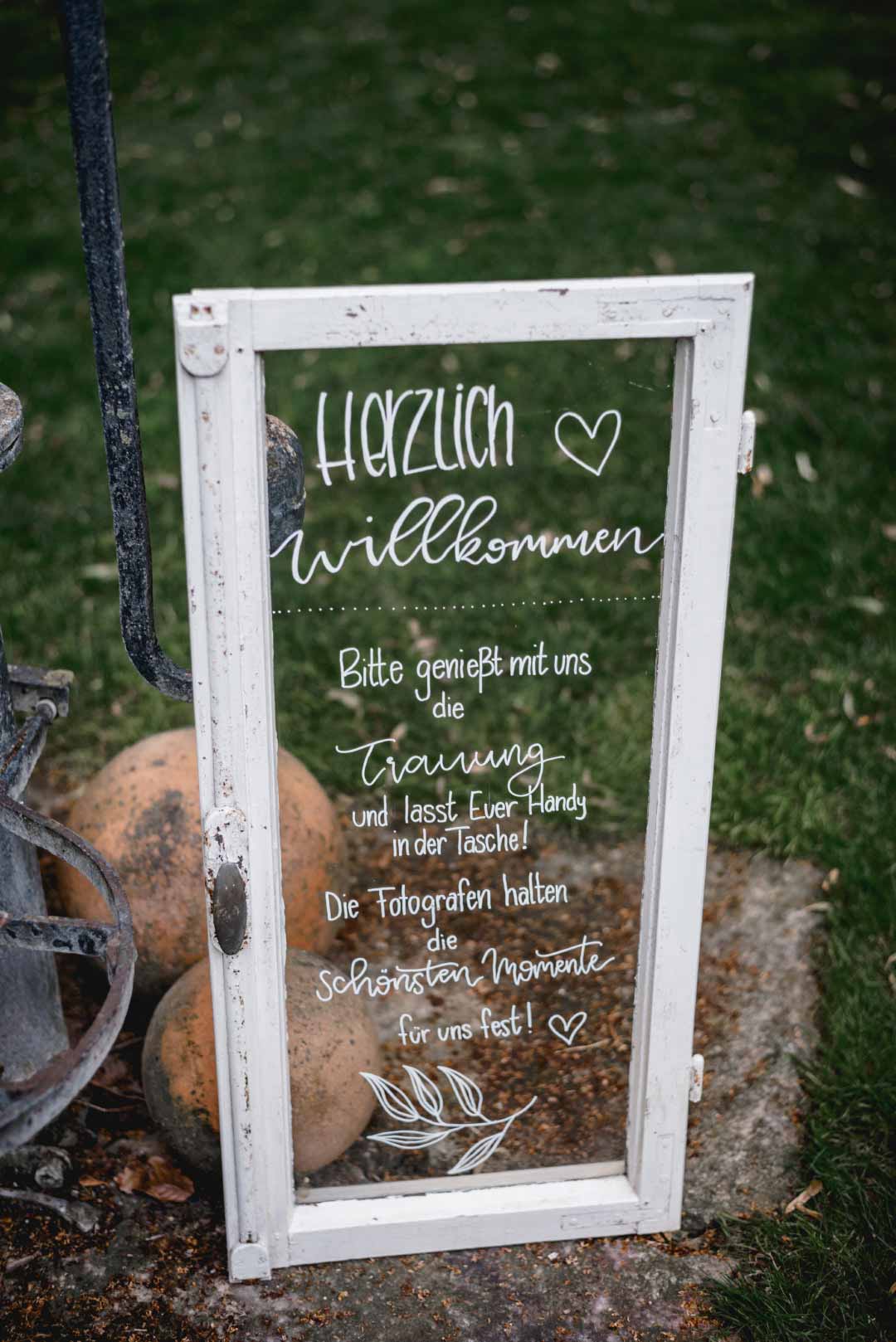 Willkommensschild bei der Hochzeit mit einem alten Fenster