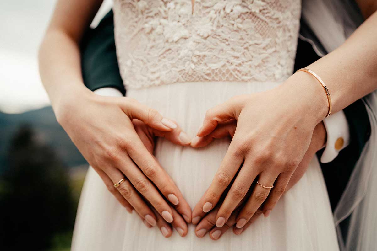 Braut und Bräutigam formen mit den Händen ein Herz