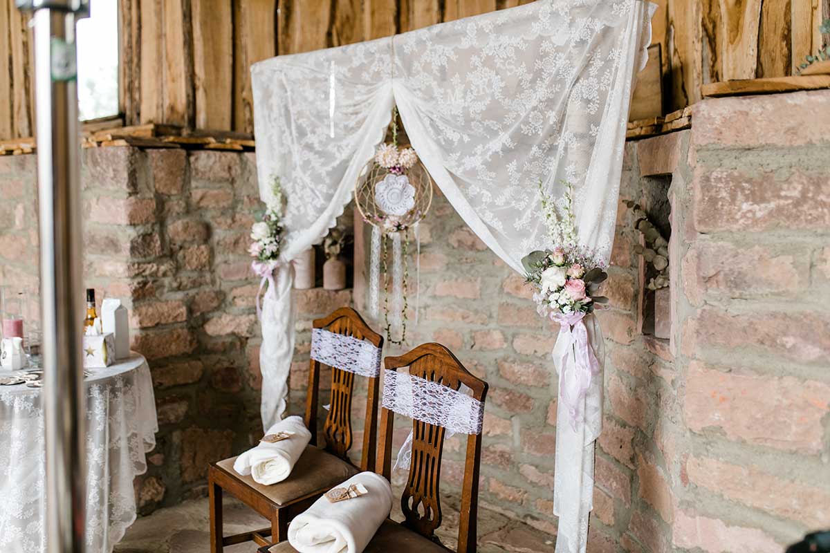 Traubogen mit Vorhang und Stühle für das Brautpaar