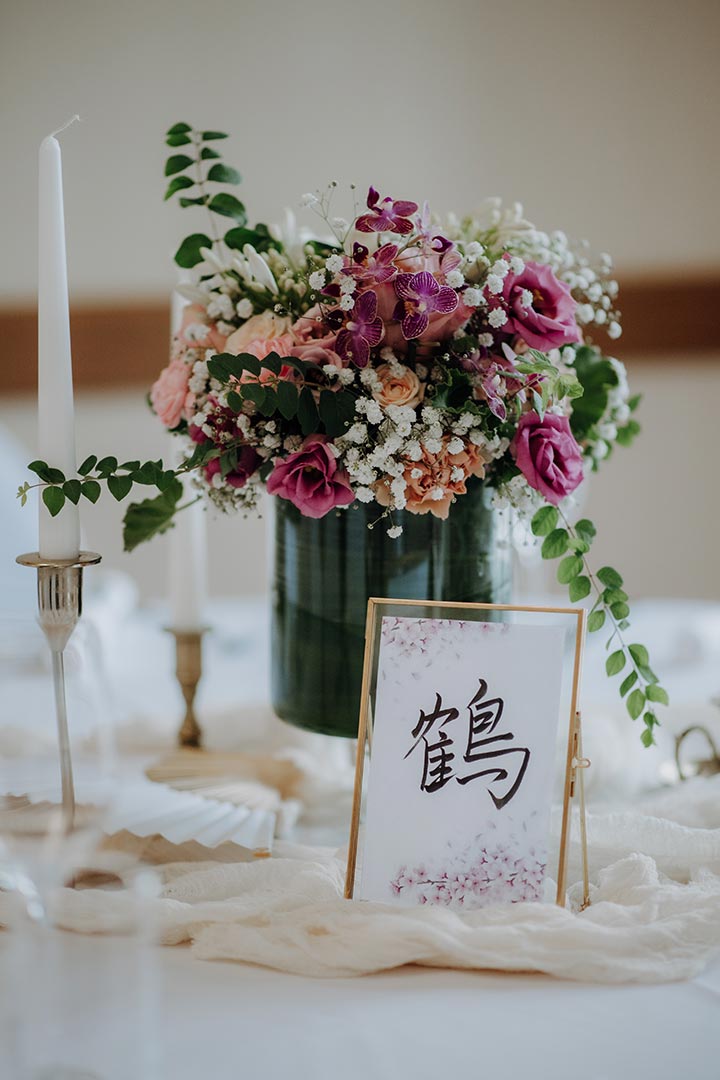Tischdeko mit Blumen, Kerzen und Tischnummer