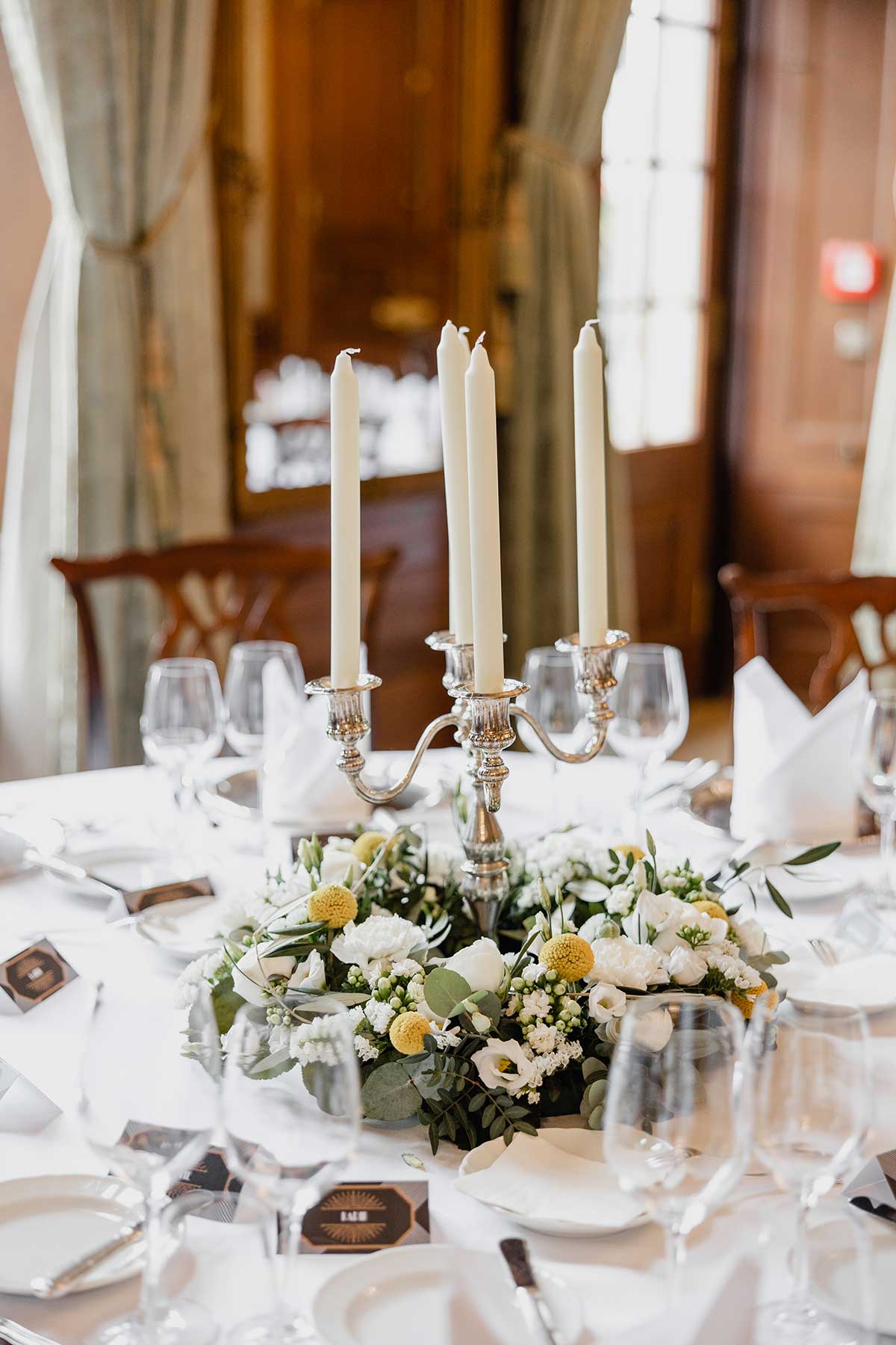 Blumenkranz mit Kerzenständer als Tischdeko bei der Hochzeit