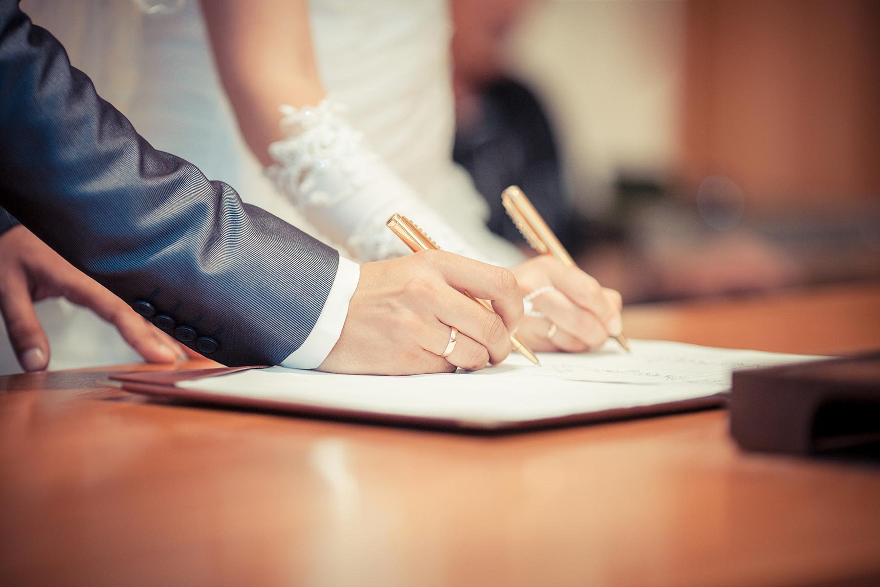 Brautpaar unterschreibt Dokument im Standesamt