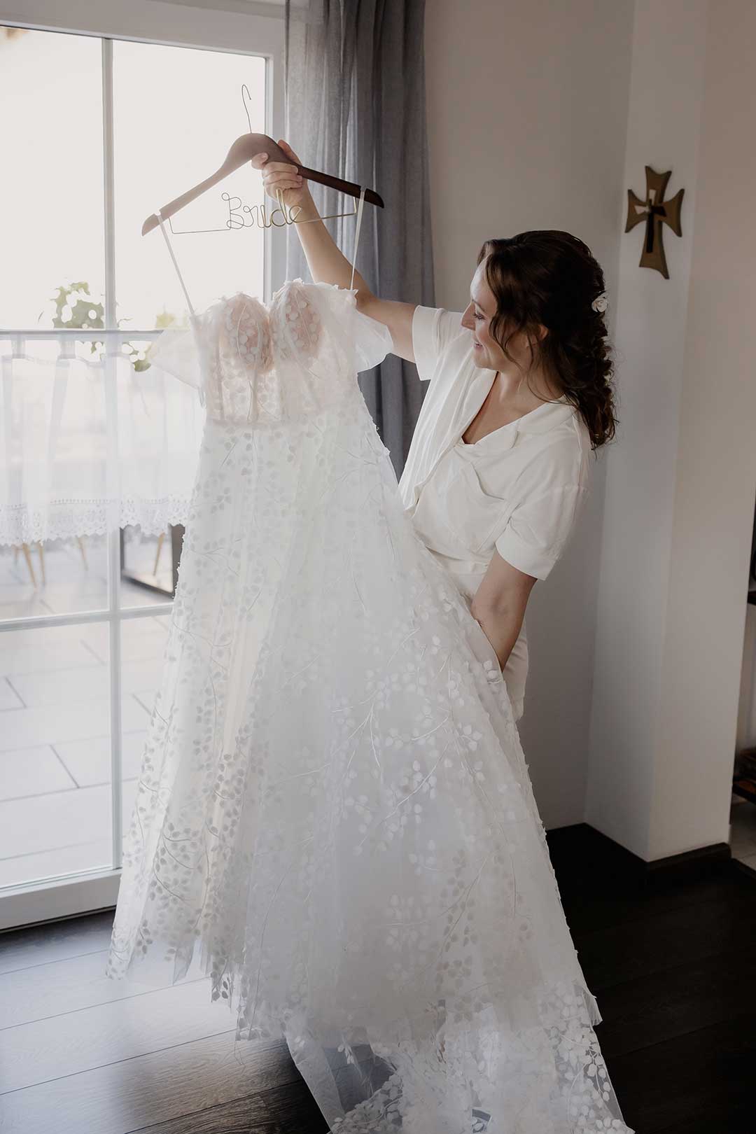 Braut schaut sich ihr Brautkleid an