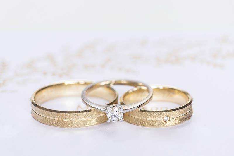 Eheringe aus Gold mit Verlobungsring aus Weißgold